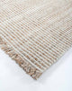 The Rhodes outdoor rug in teak and cream tones, seen close up at the corner showing the stylish weave
