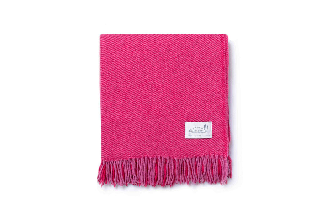 A folded bright pink throw blanket by Ruanui Station, NZ