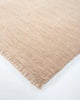 Corner of the Baya Sandringham wool rug in blush pink 'Cameo' colour, with small tasseled edge