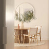 A sophisticated dining room in neutral tones with a hand braided jute floor rug in white underneath the table. 