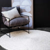 A round floor rug in braided jute fibres, whitewashed for a coastal effect. 