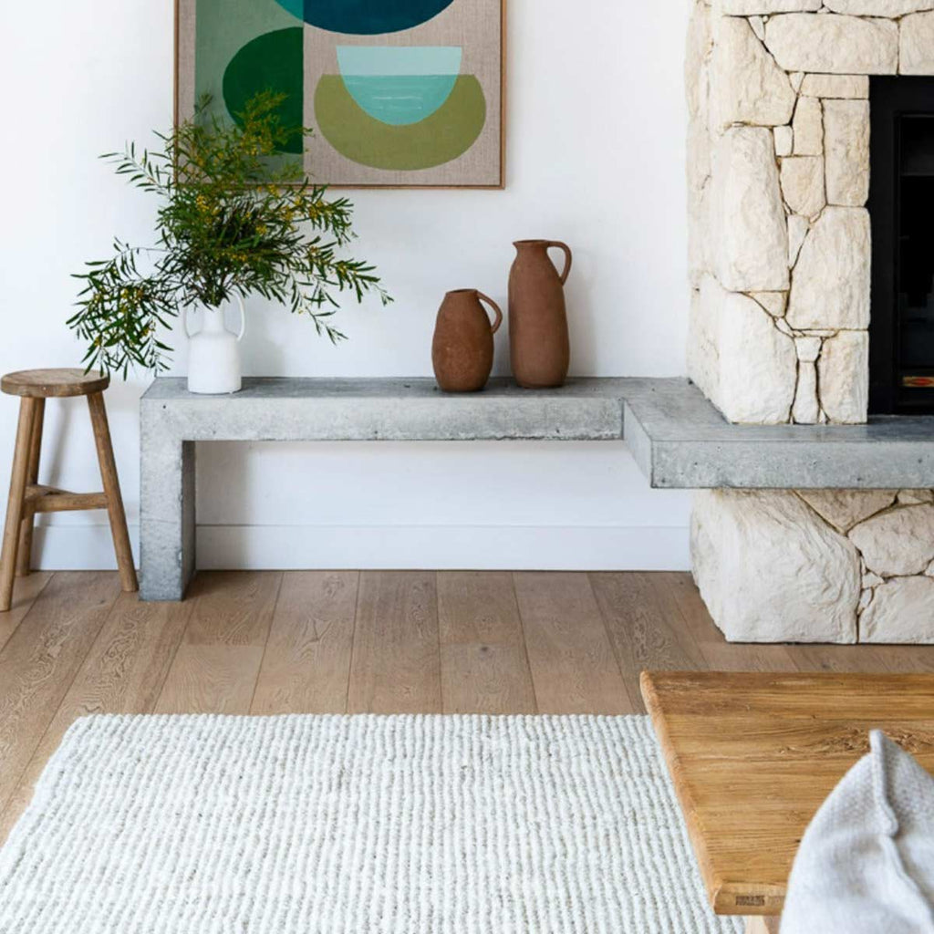 A bohemian minimalist living area with a handmade white floor rug made from whitewashed jute. 
