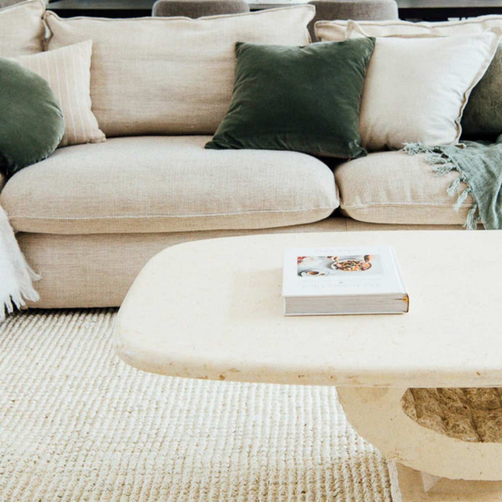An earth toned living room with a soft white floor rug in durable jute with a boucle weave. 