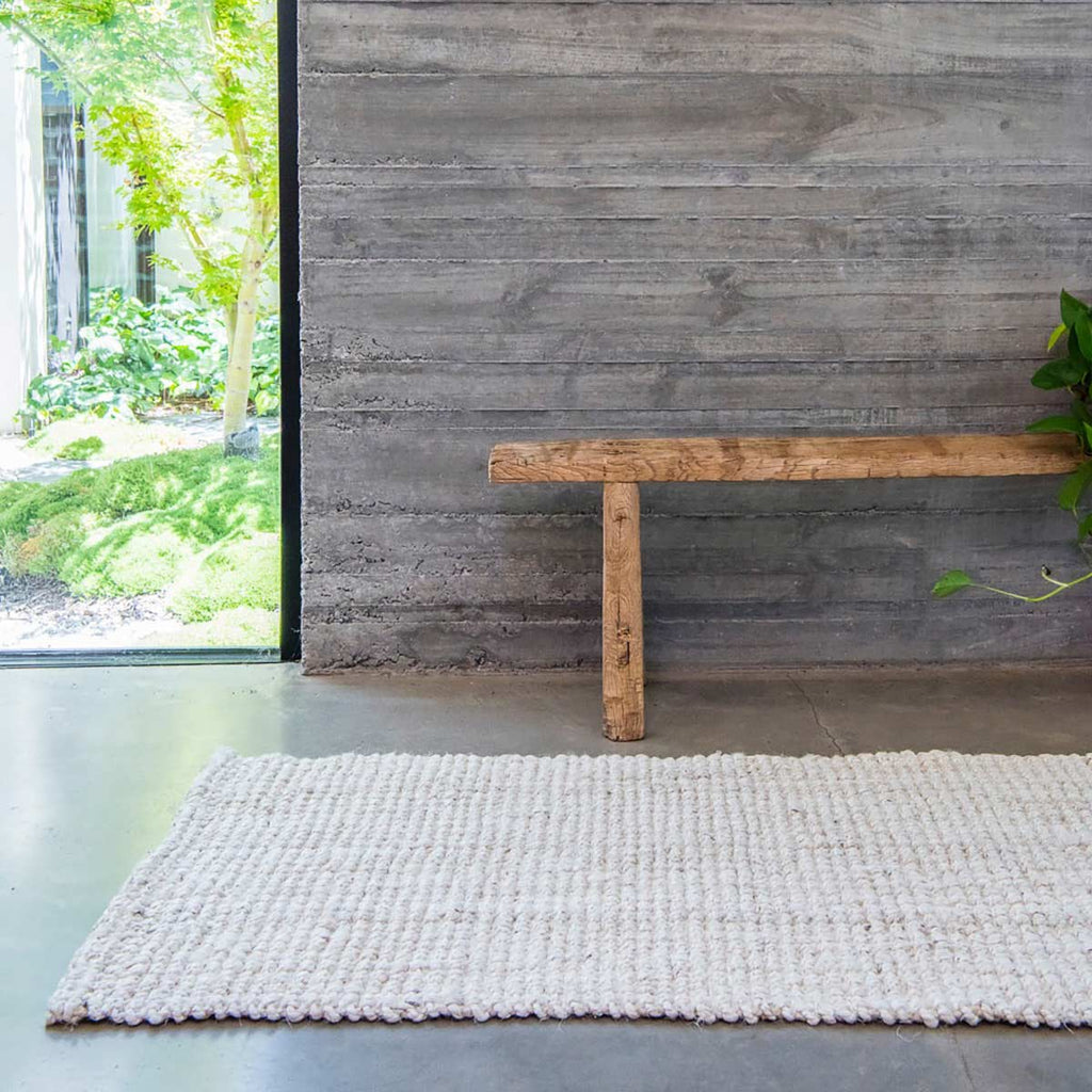 A hallway with a floor runner made with white jute in a boucle weave. 