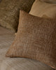 Weave Home Castel cushion in Auburn layered with olive and tan cushions.