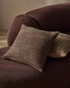 Weave Home Castel cushion in Auburn on a curved brown sofa.