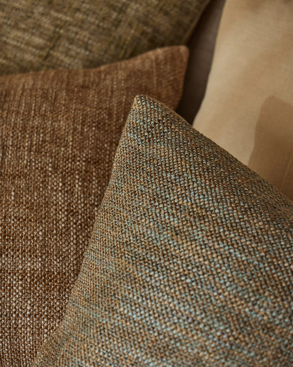 Weave Home Castel cushion in Tide layered with brown and olive cushions.