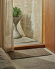 Weave Home Ivano jute doormat in Graphite styled at a timber entranceway.
