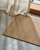 Weave Home Ivano jute doormat in Wheat at the base of a timber staircase.