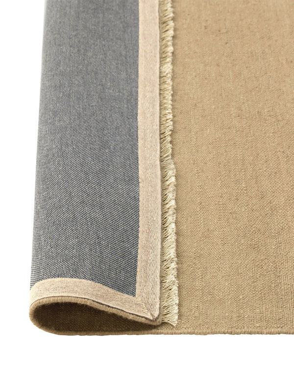 Weave Home Jacqueline wool rug in Barley, folded corner showing the cotton backing and fringed edge.