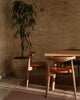 Weave Home Jacqueline wool rug in Rosewood in a sunlit room with a potted tree and timber chairs
