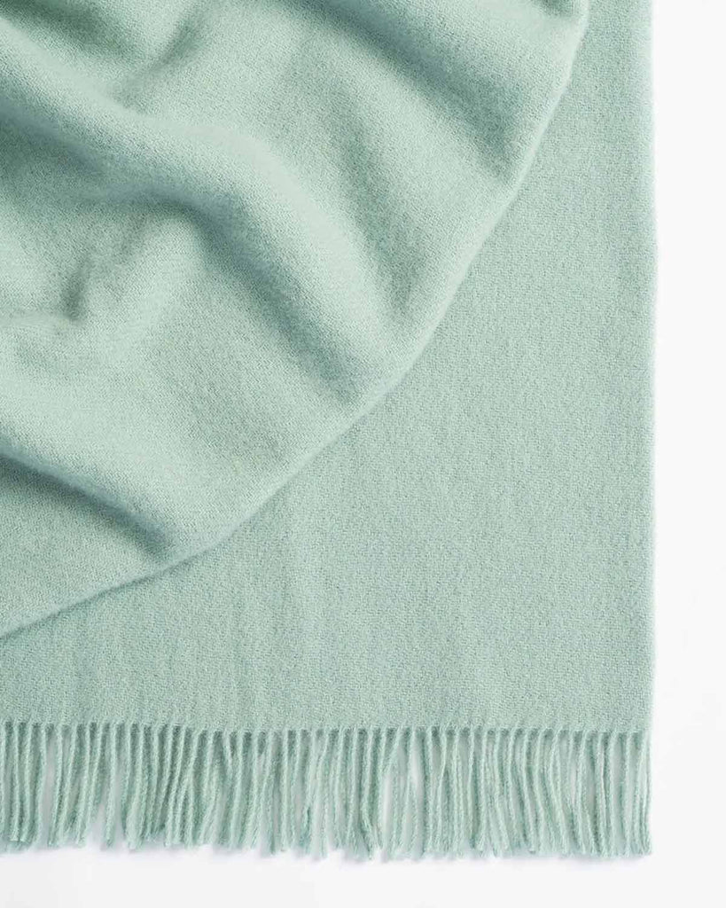 A seafoam, light blue-green throw blanket by Weave Home