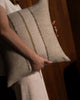 Weave Home Ottavio cushion in Willow held close, with a second cushion beside it and a wood-panelled background.