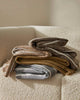 Full set of three shades of Weave Home's Piazza throw blankets, folded on a couch. 