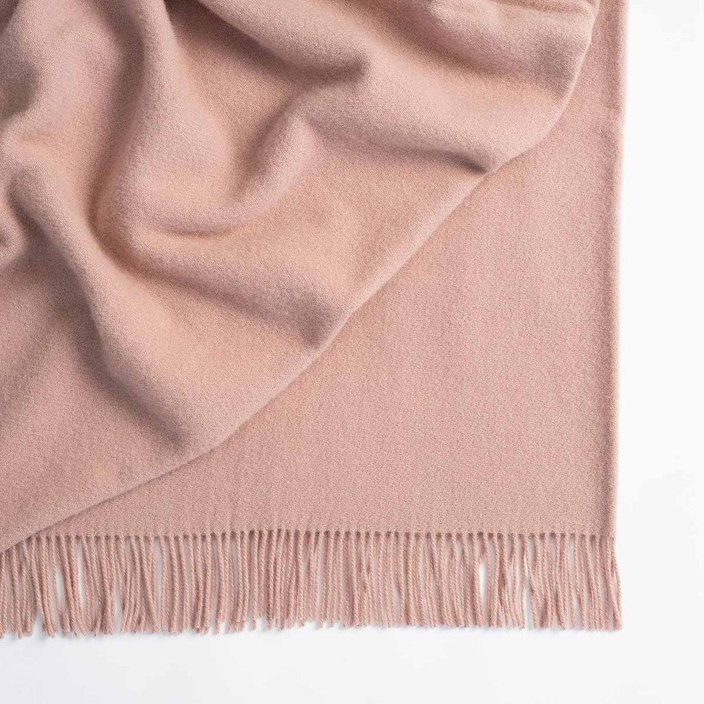 A soft, blush pink lambswool throw blanket by Weave Home