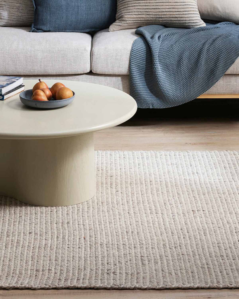 Close up of a stylish modern living room with a rug by Baya NZ in cool tones